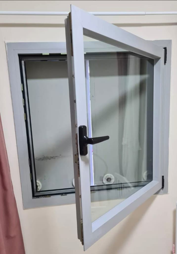 חלון מסגרת לבנה פתוח עם ידית וצירים